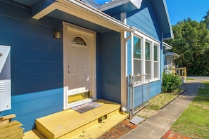 A blue house with a white door, a small porch, and a chain-link fence. - 2 Mi to Dtwn Pensacola: Historic Home w/ Patio! (Pensacola)