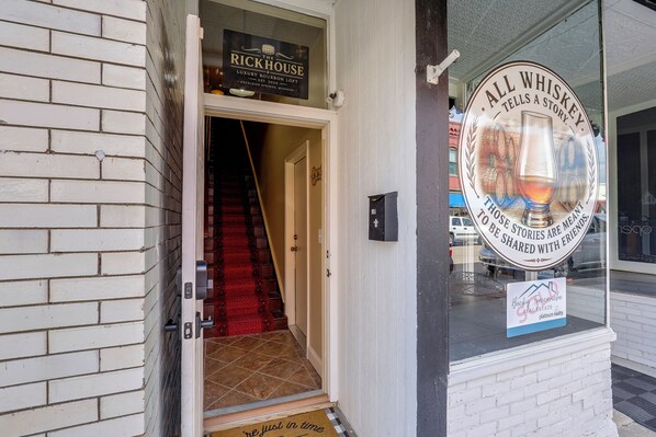 A hotel entrance with a sign for 'The Rickhouse Luxury Bourbon Loft' and a sign for 'All Whiskey Tells a Story.'
