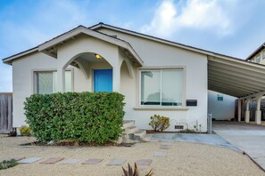 A single-story house with a blue door, a covered garage, and a well-maintained front yard with gravel and stepping stones. - Seaside Monthly Rental Across From Martin Park (Seaside)