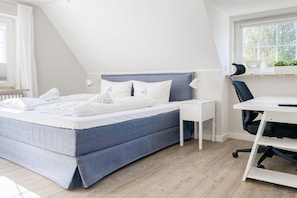 Ein Schlafzimmer mit Bett, Nachttischen, Schreibtisch und Stuhl.