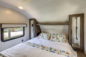 Ein Schlafzimmer mit Bett, Fenster und Tür.