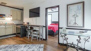 Ein kompakter Wohnbereich mit Küchenzeile, Essplatz und Schlafzimmer.