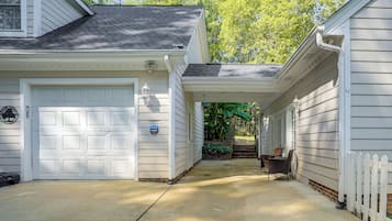 A residential property with a garage, a covered walkway, and a white picket fence.