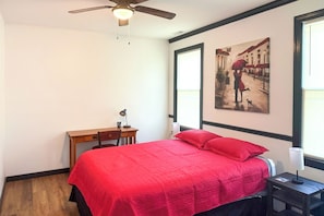 A bedroom with a bed, a desk, a chair, a ceiling fan, and a window with blinds. - 6 Mi to NCSU! Quiet & Wooded Retreat (Raleigh)