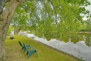 Un entorno tranquilo junto al lago con un banco y una mesa de picnic cubierta.