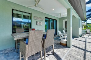 A covered patio area with wicker furniture, a ceiling fan, and a welcome sign. - Stylish Home Near Beaches & Golf in Rotonda West! (Rotonda West)