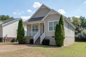 A single-story house with a front porch, a staircase leading to the entrance, and a well-maintained lawn. - Minutes From Grand Ole Opry! River Retreat (Nashville)
