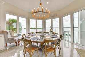 A spacious dining area with a large table, chairs, and a chandelier. - Luxury Bayfront Home, Private Dock, Steps to Beach (Englewood)