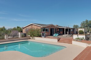 A residential property with a swimming pool, a patio area, and a brick house. - Pool, Putting Green & Mtn Views: Tucson Home (Tucson)