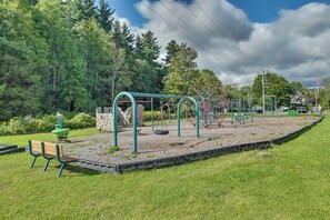 Ein Spielplatz mit Schaukeln, einer Rutsche und einer Bank.