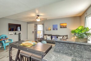 A modern living room with a sofa, a coffee table, and a dining area with a table and chairs. - Shop, Dine, Walk to Beach! South Padre Island Unit (South Padre Island)