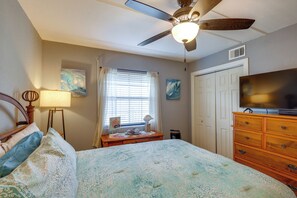 A bedroom with a bed, a ceiling fan, a television, a dresser, and artwork on the walls. - Shop, Dine, Walk to Beach! South Padre Island Unit (South Padre Island)