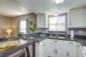 A modern kitchen with white cabinets, a granite countertop, and a built-in sink. - Shop, Dine, Walk to Beach! South Padre Island Unit (South Padre Island)