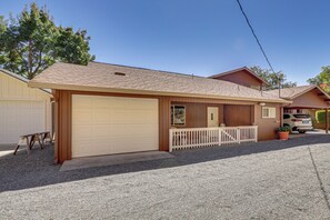A single-story house with a garage, a covered porch, and a vehicle parked in the driveway. - Panoramic Views! Clear Lake Cottage w/ Patio (Clearlake)