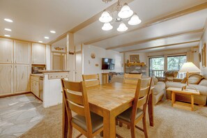 A spacious kitchen with wooden cabinets, a dining table, and a built-in oven. - Steps to Slopes! Mammoth Mountain Condo (Mammoth Lakes)