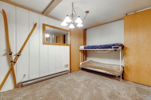 A room with bunk beds, a mirror, and skis leaning against the wall. - Steps to Slopes! Mammoth Mountain Condo (Mammoth Lakes)