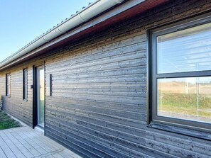 A modern building with a wooden facade, large windows, and a visible door. - 8 Person Holiday Home in Hirtshals (Hirtshals)