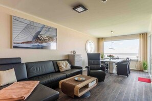 Ein modernes Wohnzimmer mit einer Couch, einem Couchtisch und einem Essbereich mit Stühlen.
