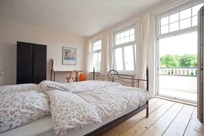 Ein Schlafzimmer mit einem Bett, einem Schreibtisch und einem Fenster.
