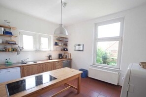 Eine Küche mit Holzausstattung, einem Einbauherd, einem Fenster und einer Heizung.