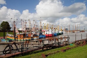 A harbor with various boats docked, including a prominent orange and green ship named 'HINDEKER.' - Holiday home with 4 bedrooms (Jemgum-Ditzum)