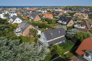 Ein Wohngebiet mit Häusern, einige davon mit angebauten Garagen, und ein großes Haus mit einem markanten Balkon.