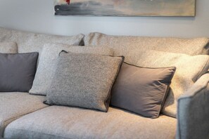 Ein beiges Sofa mit drei Kissen.