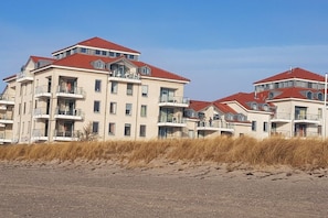 A multi-story residential building with balconies, located near a sandy beach. - Freeport on the South Beach (Fehmarn)
