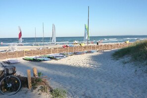 A sandy beach with multiple sailboats and a bicycle. - Holiday apartment in Damp with swimming pool (Damp)