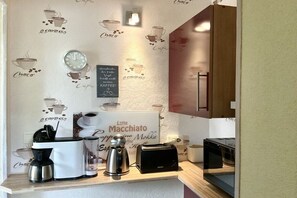 Eine Küchenzeile mit einer Kaffeemaschine, einem Toaster und einem Schild mit der Aufschrift 'Latte Macchiato'.
