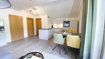 A modern apartment with a kitchen, dining area, and a living room.