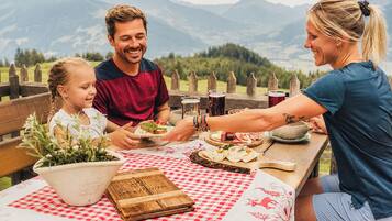 A family dining outdoors with a mountain view.