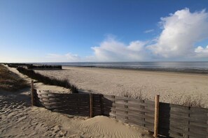 A sandy beach with a wooden fence and dunes. - Holiday apartment with 2 bedrooms (Cuxhaven)