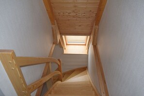 A wooden staircase with a skylight leading to an upper floor. - Holiday home with 3 bedrooms (Dorum-Neufeld)