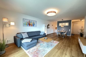 A modern living room with a grey sofa, a coffee table, and a colorful rug. - Holiday apartment with 2 bedrooms (Kappeln)