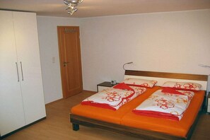 A bedroom with a bed, a wardrobe, and a door. - "Beach apartment Borkum" (Borkum)