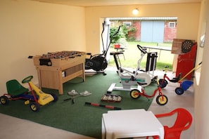 A room with a foosball table, exercise equipment, and children's toys. - Holiday apartment with 2 bedrooms (Neuenkirchen OT Delmsen)