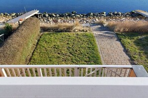 Eine Terrasse mit Blick auf eine felsige Küste und eine Rasenfläche.