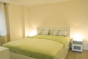 A bedroom with a bed, two bedside tables, and a nightstand. - Holiday apartment with 1 bedroom (Fehmarn OT Burg)