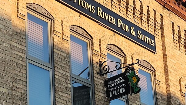 Rakennuksessa on kyltti, jossa lukee: ”Froggy Bottoms River Pub & Suites”.