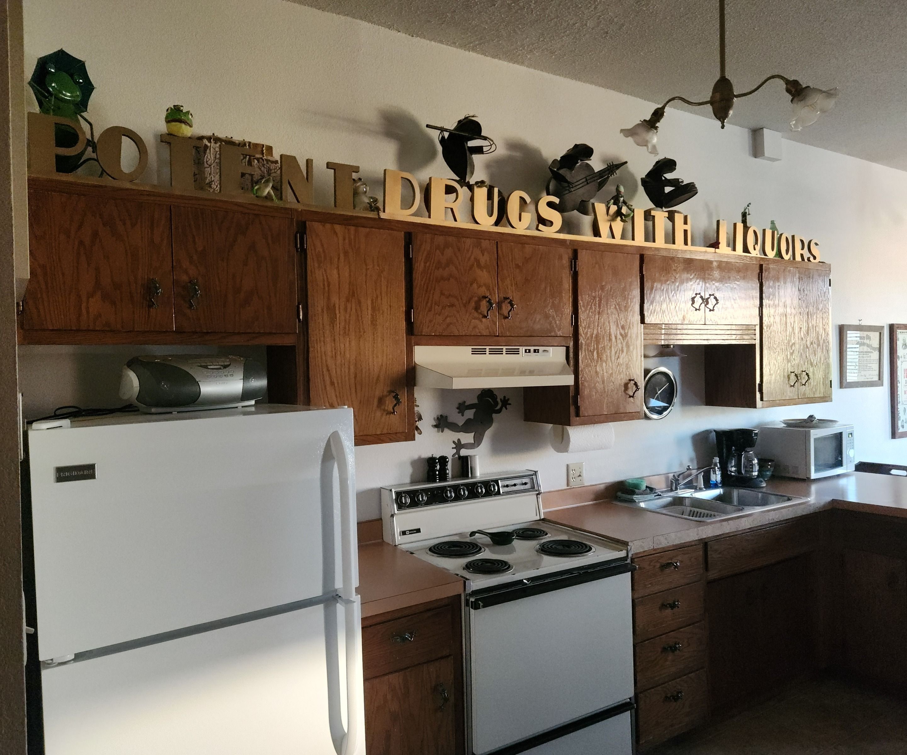 A kitchen with wooden cabinets, a white refrigerator, a stove, and a microwave.