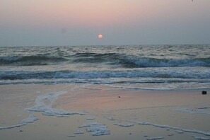A beach with waves and a visible sun near the horizon. - Holiday home Baltic Sea barrier-free (Waabs)