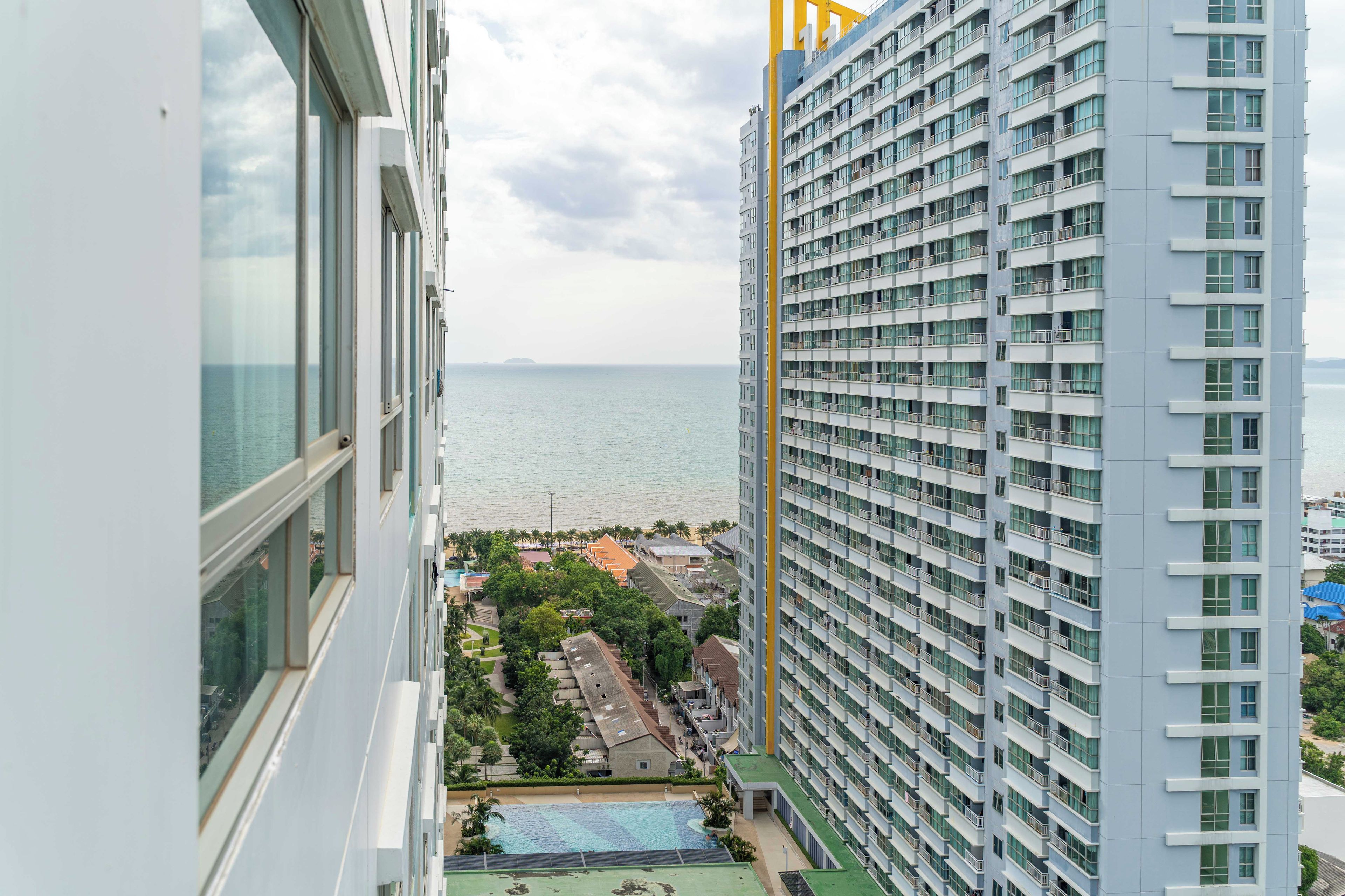 Ein Hochhaus mit Blick auf das Meer und einem Poolbereich.
