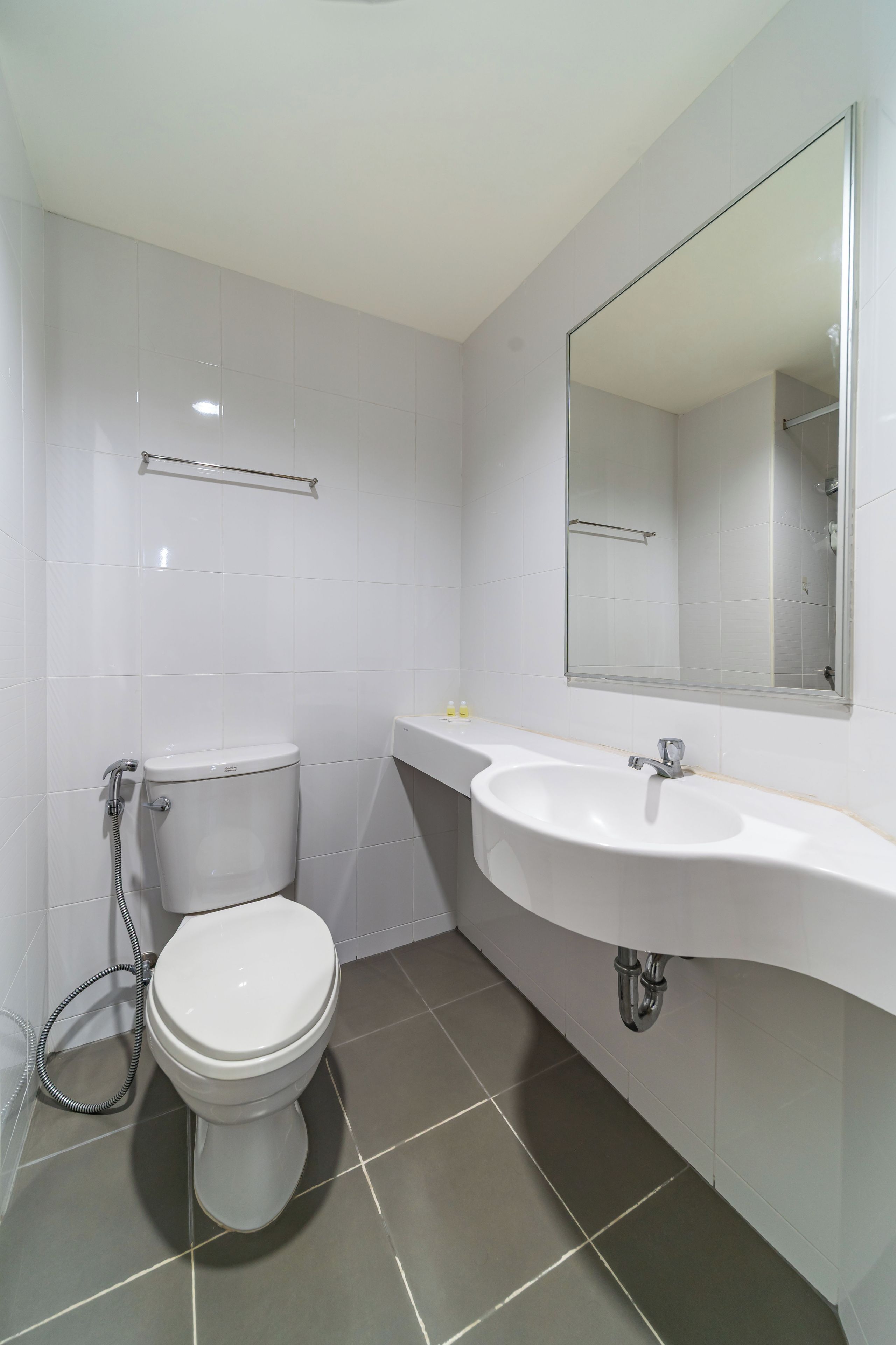 Een moderne badkamer met toilet, wastafel en spiegel.