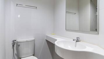 Een moderne badkamer met toilet, wastafel en spiegel.
