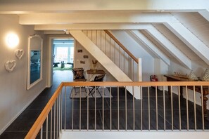 A staircase with a wooden handrail leading to an upper floor. - resin passion || Braunlage (Braunlage)