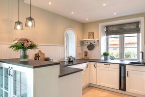 A kitchen with white cabinets, a black countertop, and a window with a view.