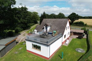 A two-story house with a flat roof, a balcony, and a small attached garage. - Holiday apartment in Boren with swimming pool (Boren)