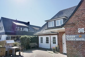 A residential property with a brick facade, a white door, and a sign indicating the year 1955. - Holiday apartment with 2 bedrooms (Wenningstedt-Braderup)