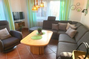 A living room with a sofa, armchairs, a coffee table, a TV, and a plant. - ||----------------------Ahoy with garden---------------------|| (Dahme)
